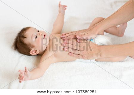 Baby massage. Mother massaging infant belly