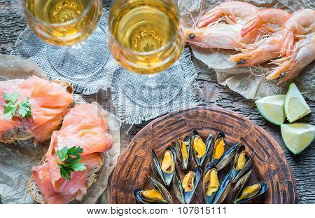 Seafood With Two Glasses Of White Wine On The Wooden Table
