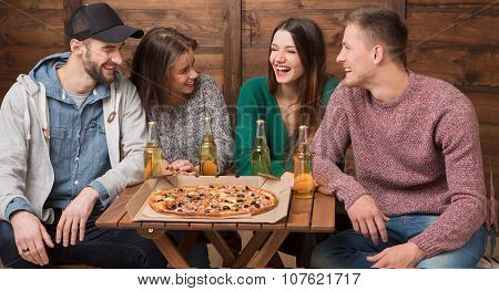 Happy friends resting in pizzeria