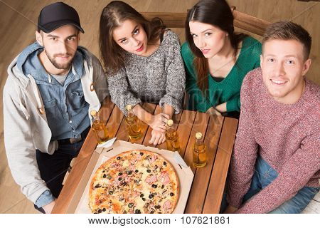 Happy friends resting in pizzeria
