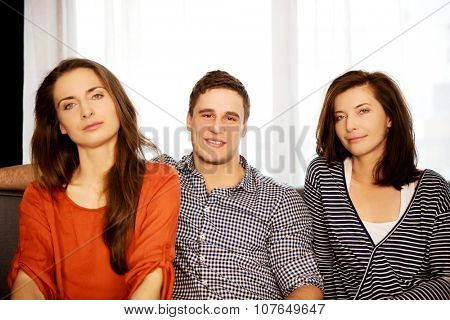 Sisters and brother sitting on the sofa.