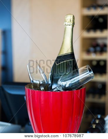 drink, holidays, celebration, alcohol and objects concept - close up of champagne bottle and glasses cooling in ice bucket at restaurant
