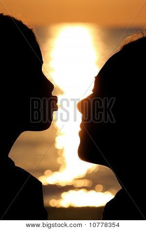 Девушка тянется с Kiss женщине напротив солнечными лучами