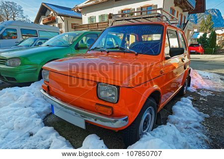 Row of shiny cars of bright colors parked in the street of a charming Garmisch-Partenkirchen. It is a mountain resort town in Bavaria southern Germany in the heart of the Alps