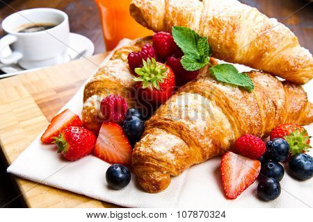 Fresh Tasty Croissants With Berries On Wooden Background