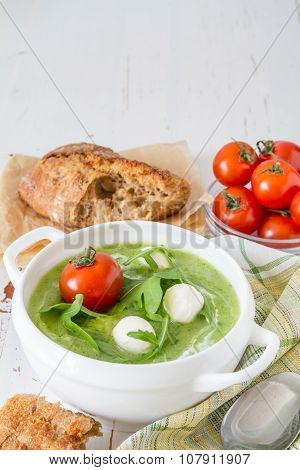 Arugula and tomatoes puree soup in white bowl