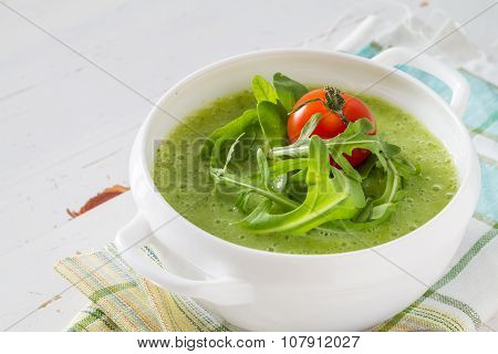 Arugula and tomatoes puree soup in white bowl