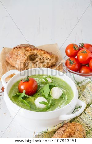 Arugula and tomatoes puree soup in white bowl