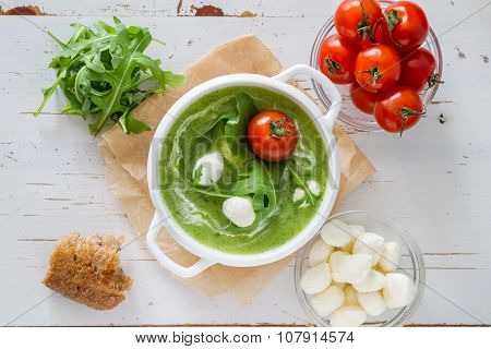 Arugula and tomatoes puree soup in white bowl