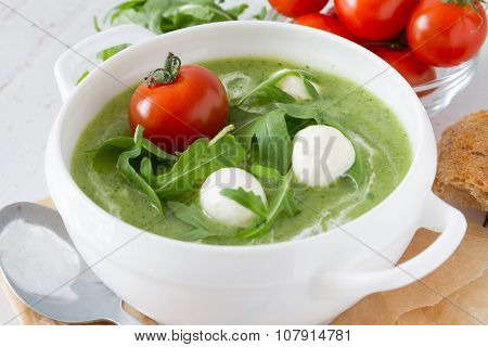 Arugula and tomatoes puree soup in white bowl