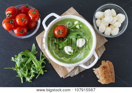 Arugula and tomatoes puree soup in white bowl