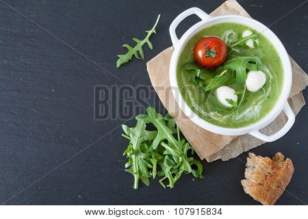 Arugula and tomatoes puree soup in white bowl