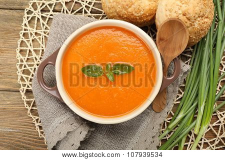 Carrot cream-soup with buns on table close up