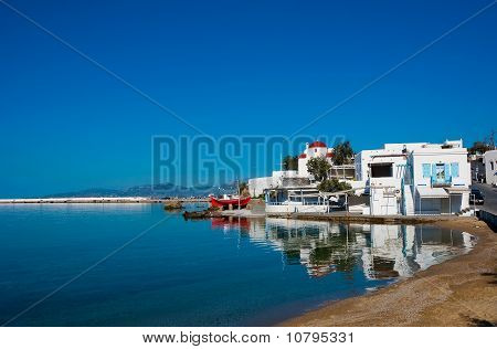La famosa taverna sulla riva del mare della baia dell'isola di Mykonos con una barca rossa e la Chiesa