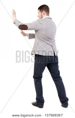back view of business man pushes wall. Isolated over white background. Rear view people collection. backside view of person.  a bearded man in a jacket ran into an obstacle.