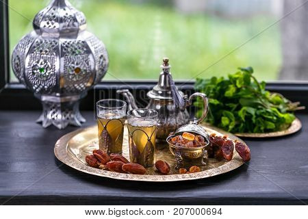 Moroccan Mint Green Tea in Two Glasses and a Teapot With Fresh Mint and Sugarcubes.