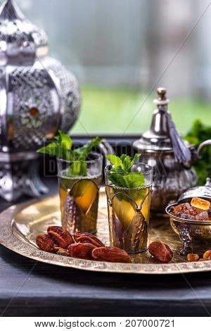 Moroccan Mint Green Tea in Two Glasses and a Teapot With Fresh Mint and Sugarcubes.