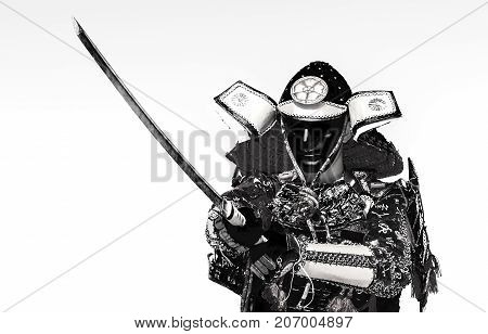 Samurai in ancient armor with a sword ready to attack close-up
