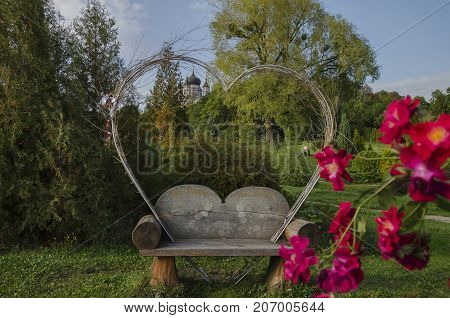 Autumn in the park beautiful bench in the shape of the heart with the inscription: for a share for good luck against the backdrop of a large Orthodox cathedral Ukraine