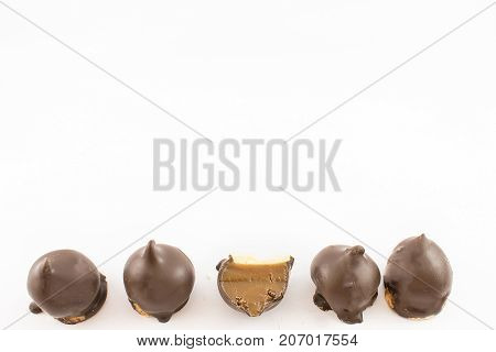 Pattern of four whole cones and one cut in half. Stuffed with dulce de leche and chocolate fudge. White background.