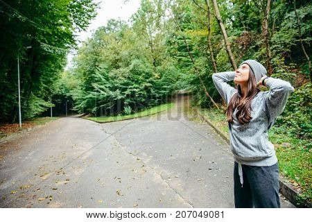 woman stretching in city park in autumn day
