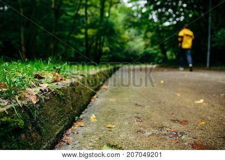 man runnin in autumn park with music in rainy weather