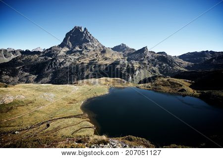 Midi Dossau Peak reflected and Gentau lake. Ossau Valley, Pyrenees National Park, Pyrenees, France.