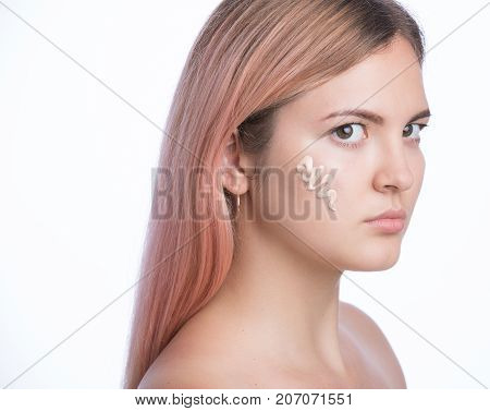 Young beautiful woman applying foundation base make up.. Isolated on white