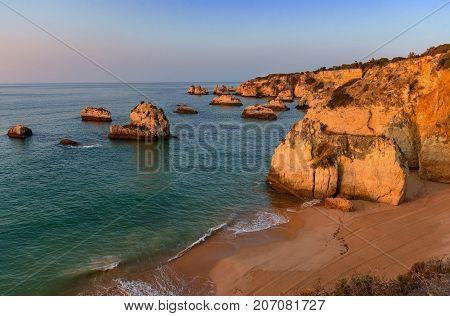 Sunrise at Praia da Donna Anna coastline in Algarve Portugal