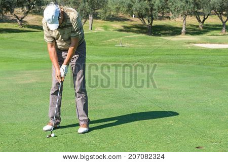 A golfer  he trains   playing in a tournament