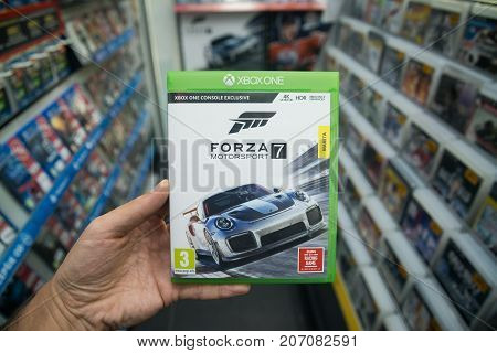 Bratislava, Slovakia, october 2, 2017: Man holding Forza 7 videogame on Microsoft XBOX One console in store