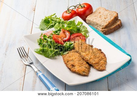 breaded fish fillet with salad