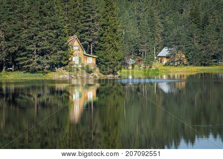 Wooden cottage on Shiroka polyana lake between forest. Pazardzhik Region, Bulgaria