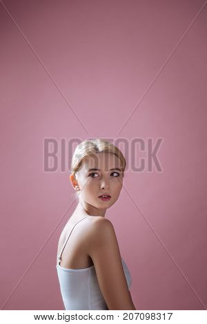 The weaker sex. Young woman standing in semi position and holding hands together while working in studio