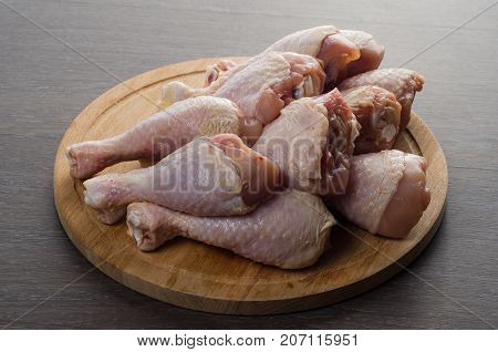 Fresh raw chicken legs arrangement on a kitchen cutting board