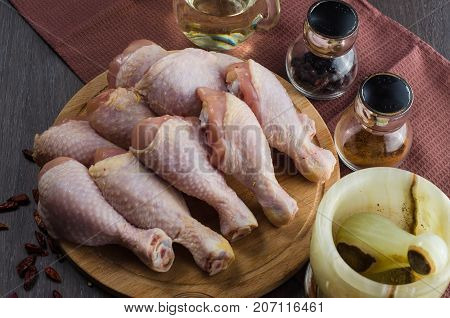 Fresh raw chicken legs arrangement on a kitchen cutting board
