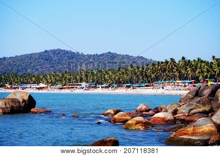 Palolem beach, South Goa, India. One of the best beaches in Goa. Colorful beach huts and palm trees on the coast. Luxury leisure.