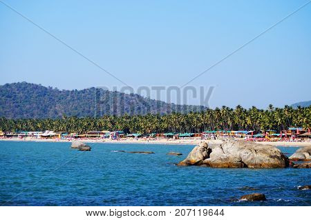 Palolem beach, South Goa, India. One of the best beaches in Goa. Colorful beach huts and palm trees on the coast. Luxury leisure.