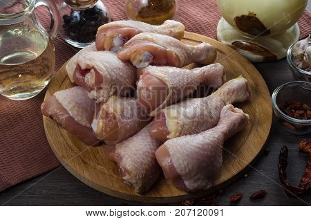 Fresh raw chicken legs arrangement on a kitchen cutting board