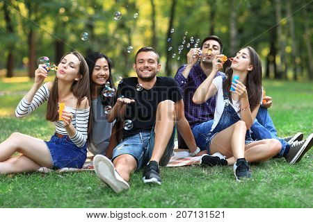 Five Friends Women And Men Inflate Soap Bubble Outdoors