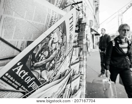 PARIS FRANCE - OCT 3 2017: Pedestrians near the Times newspaper with socking title and photo at press kiosk about the 2017 Las Vegas Strip shooting in United States with about 60 fatalities and 527 injuries