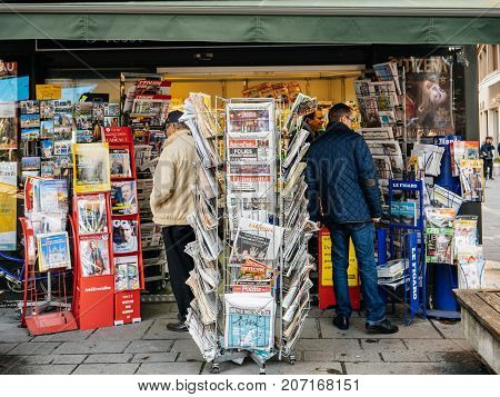 PARIS FRANCE - OCT 3 2017: People Seniors buying international newspapers at kiosk with socking title photos at about the 2017 Las Vegas Strip shooting in United States with about 60 fatalities and 527 injuries