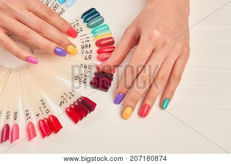 Well-groomed hands and nail color samples. Female hands with pastel manicure and nail color palette. Manicure nail polish color samples.
