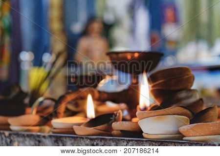 Burning old textured candles with defocussed background of the most popular Hindu shrines outside India - Batu Caves. Mood of sacrament and revelation.