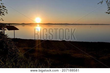 Golden sun sinks over the lake in the evening, golden water, South Ural lake Uvildy