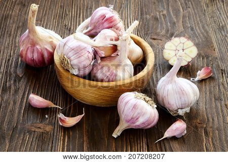 Garlic in a wooden bowl on the kitchen table