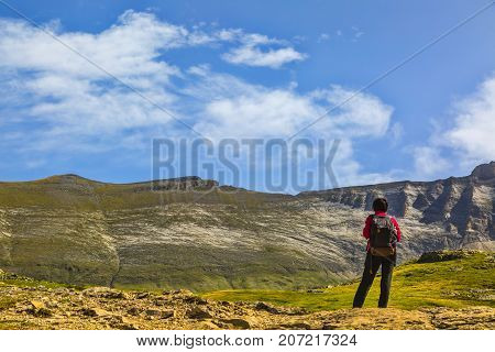 Female hiker admiring the landscape from the center of the glacial Circus of Troumouse one of the largest from the Europe.