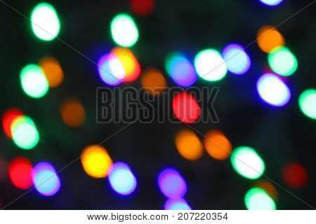 Bokeh of multicolored highlights on a black background. Celebration atmosphere.