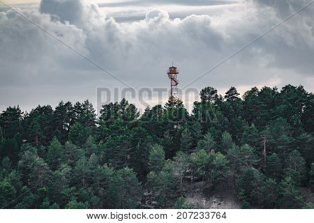 Long shot of fire watching hut over the forest at dusk with clouds