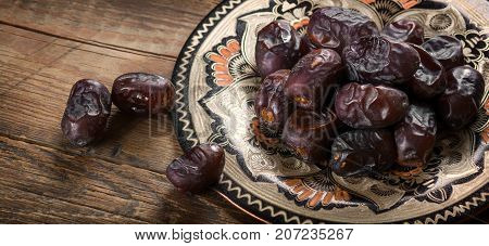Fresh sweet dates on wooden background, close up